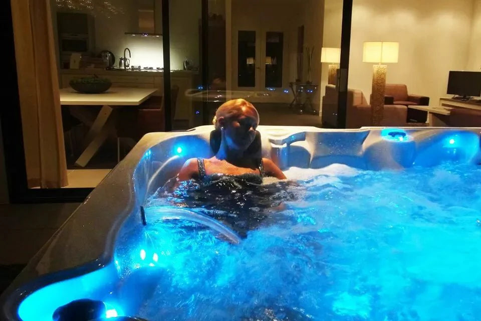 Baignade de nuit dans un spa Passion Spas avec éclairage LED bleu
