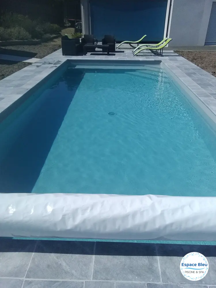 Bassin à eau bleu foncé avec couverture à lames enroulée