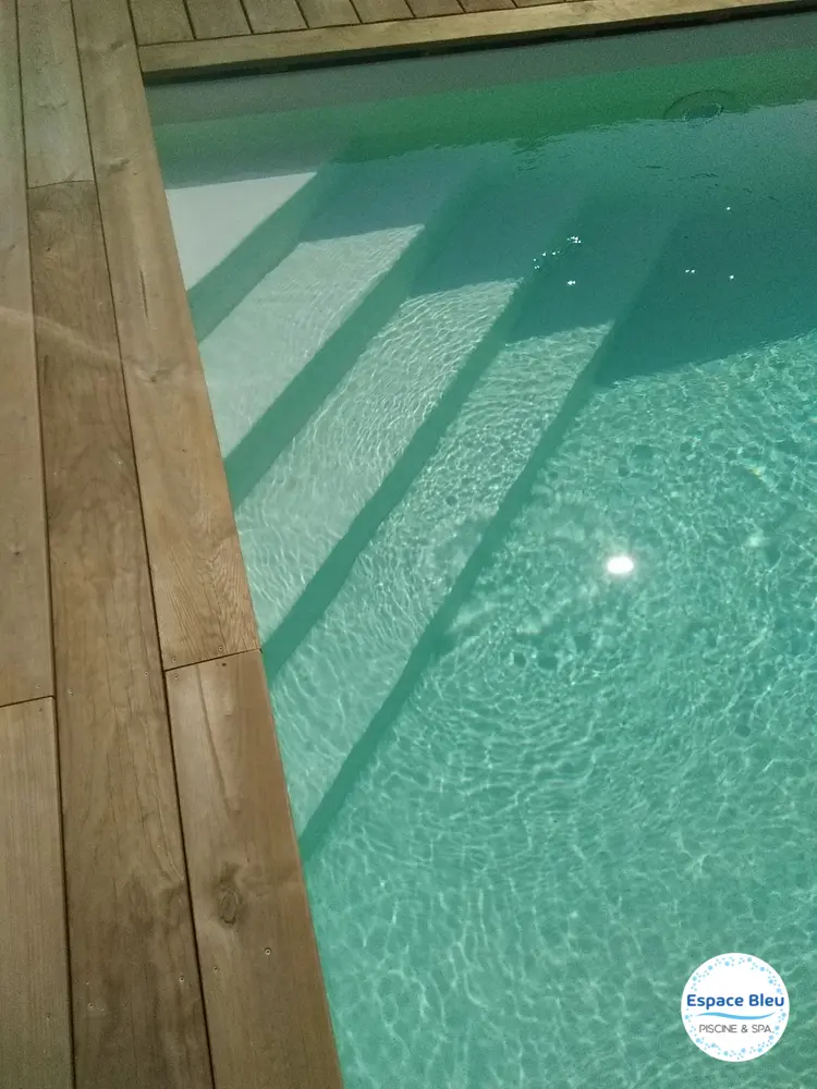 Escalier immergé d’une piscine avec bordure bois