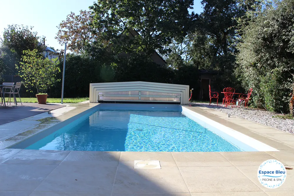 Piscine avec abri bas ouvert dans un jardin