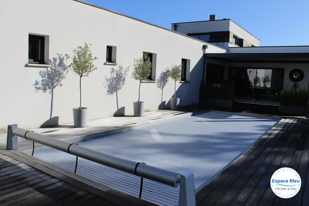 Volet roulant sur piscine, façade blanche en arrière-plan