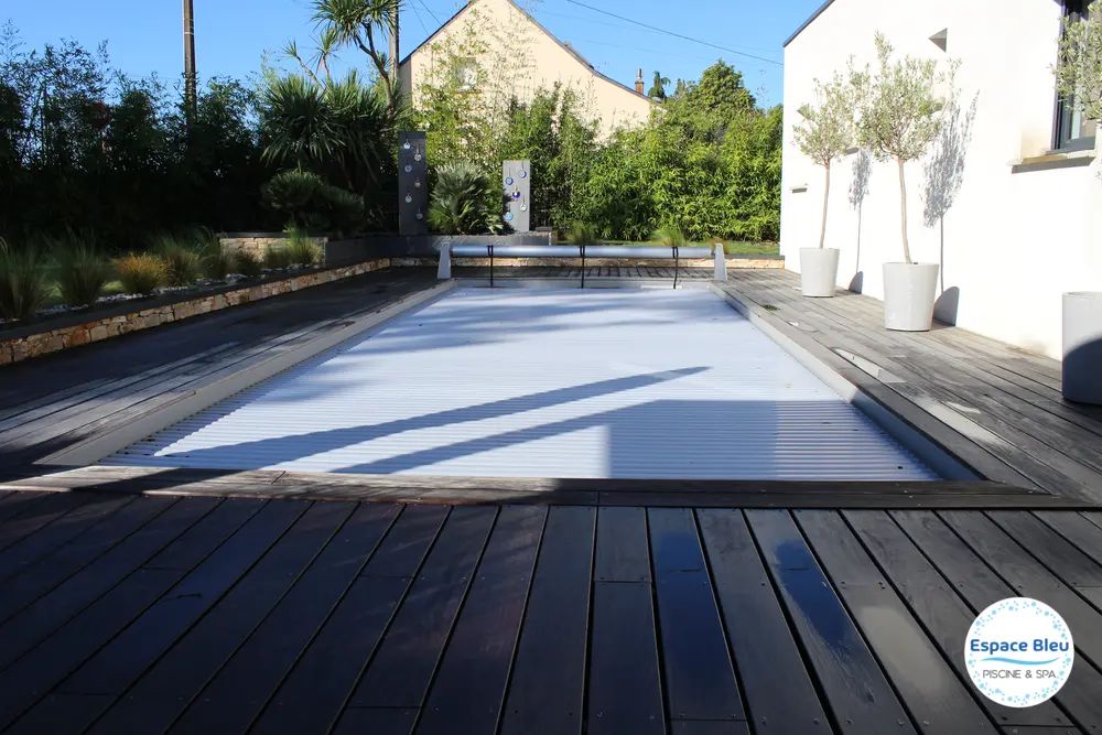 Piscine avec volet gris clair et terrasse bois
