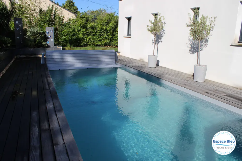 Piscine à eau turquoise devant une maison contemporaine