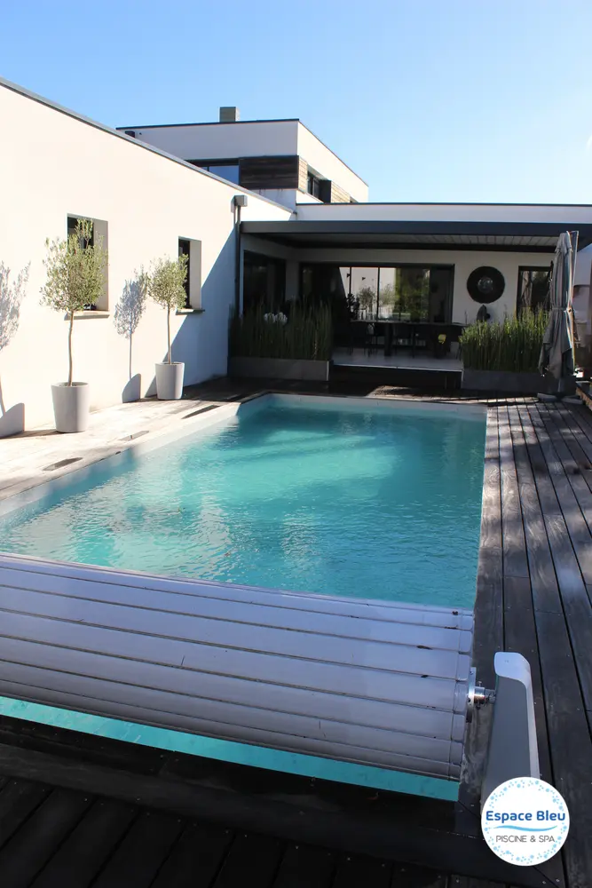Piscine avec volet roulant ouvert et terrasse bois