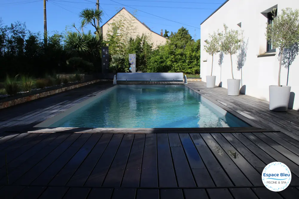 Piscine devant une maison contemporaine, terrasse bois foncé
