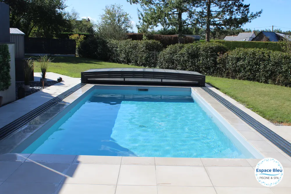 Piscine avec abri bas et plage en dalles