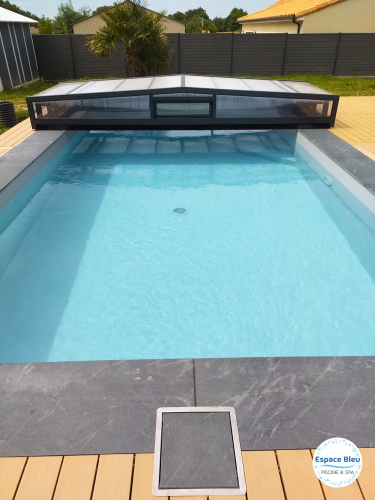 Piscine avec abri bas et plage en pierre