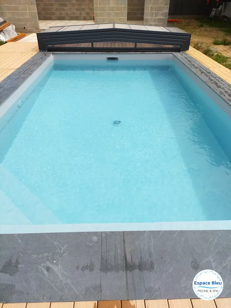 Piscine avec volet et terrasse en bois composite clair