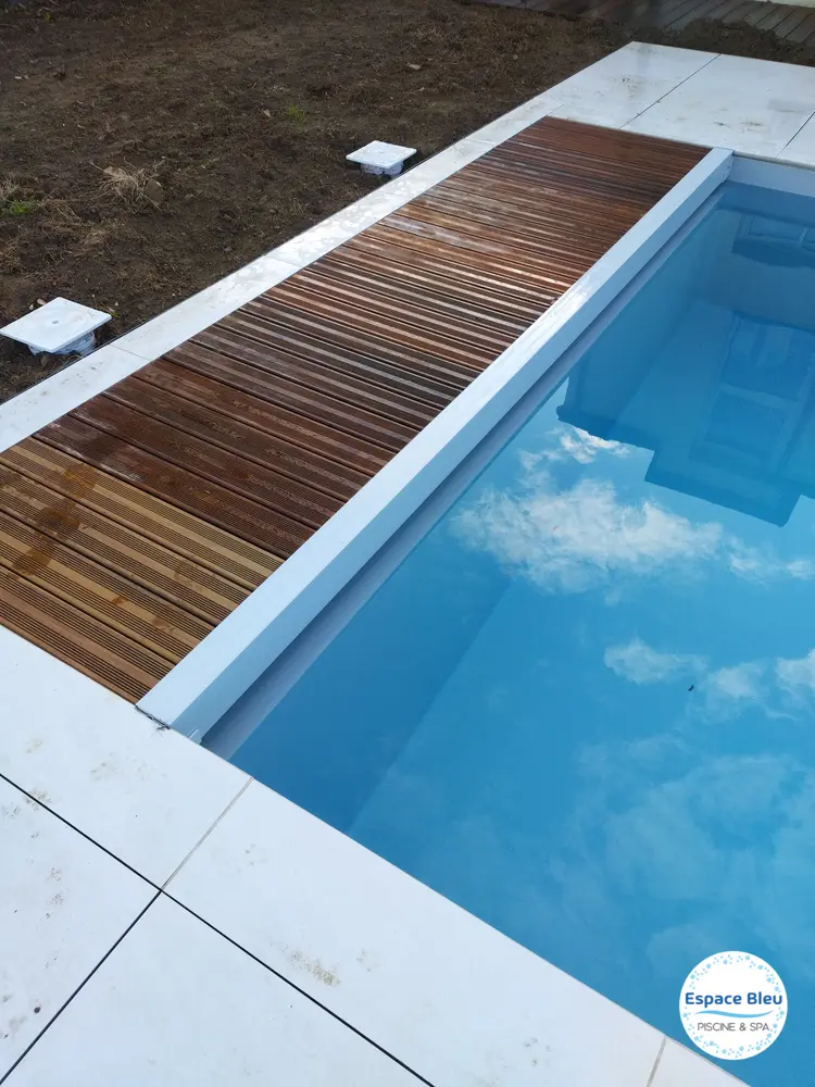 Piscine avec caillebotis bois, ciel refleté dans l’eau