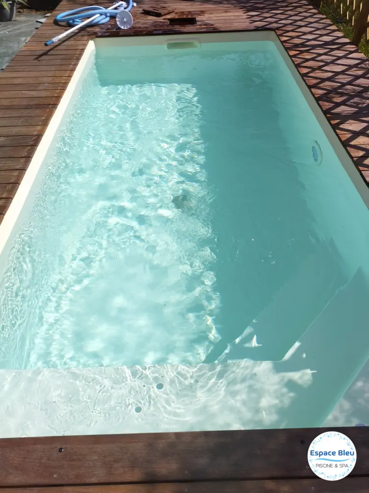 Piscine turquoise vue de dessus avec margelle blanche