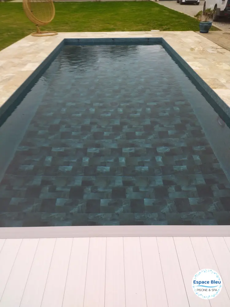 Piscine au revêtement gris foncé et pelouse