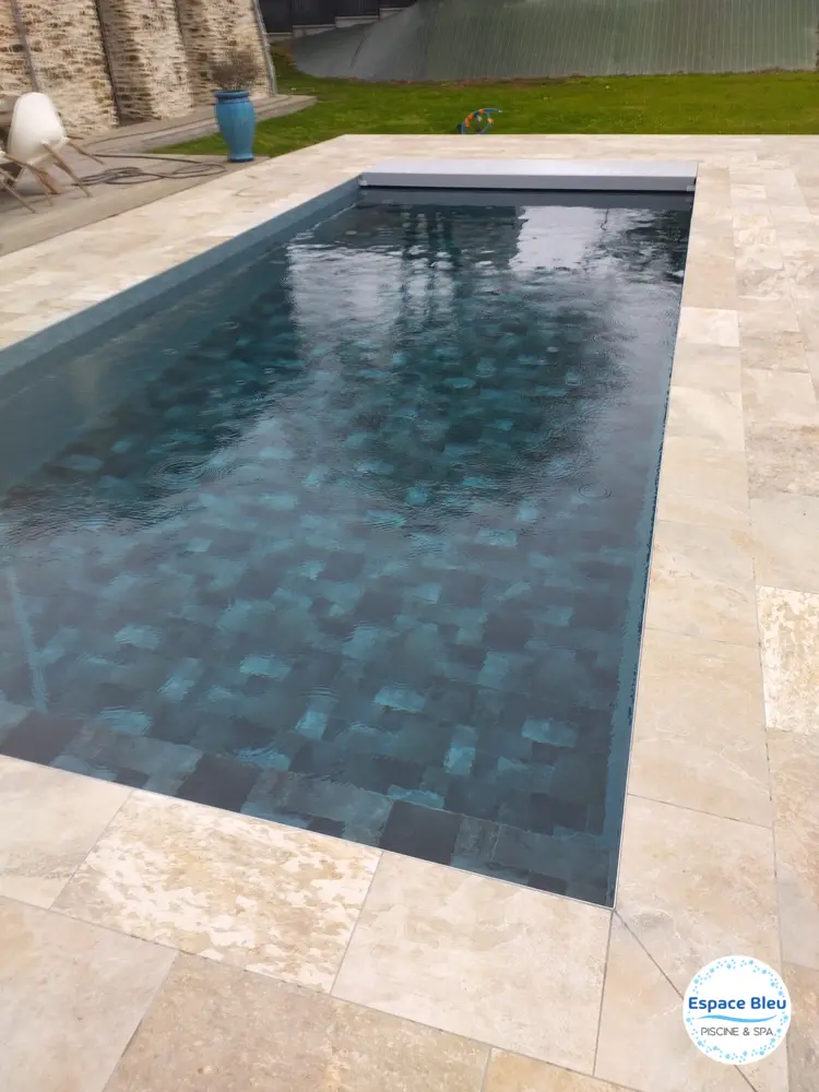 Piscine à eau sombre et margelle en pierre