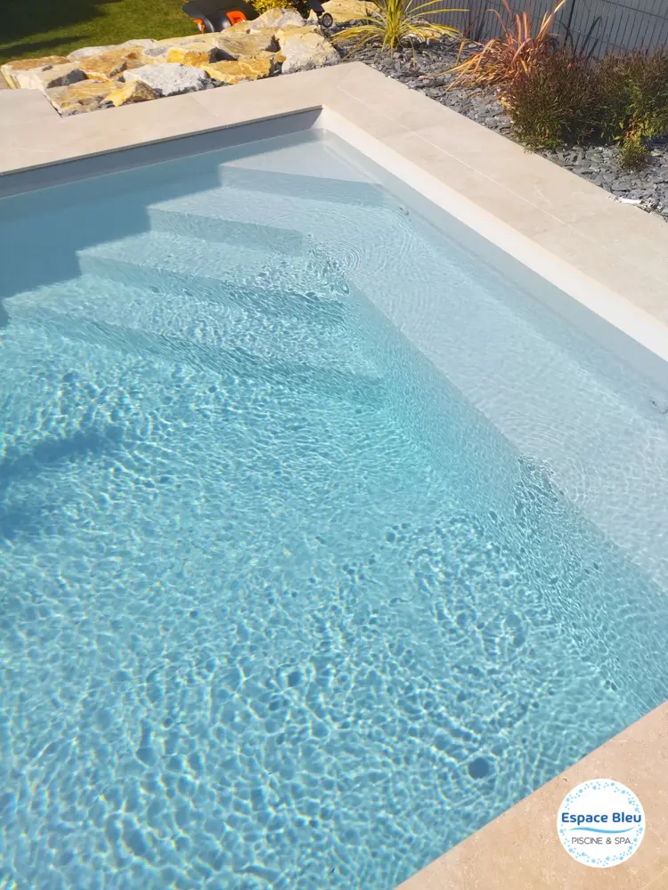 Escalier et banquette d’une piscine bleu clair