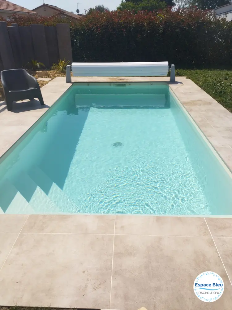 Piscine à eau turquoise avec volet en bout de bassin