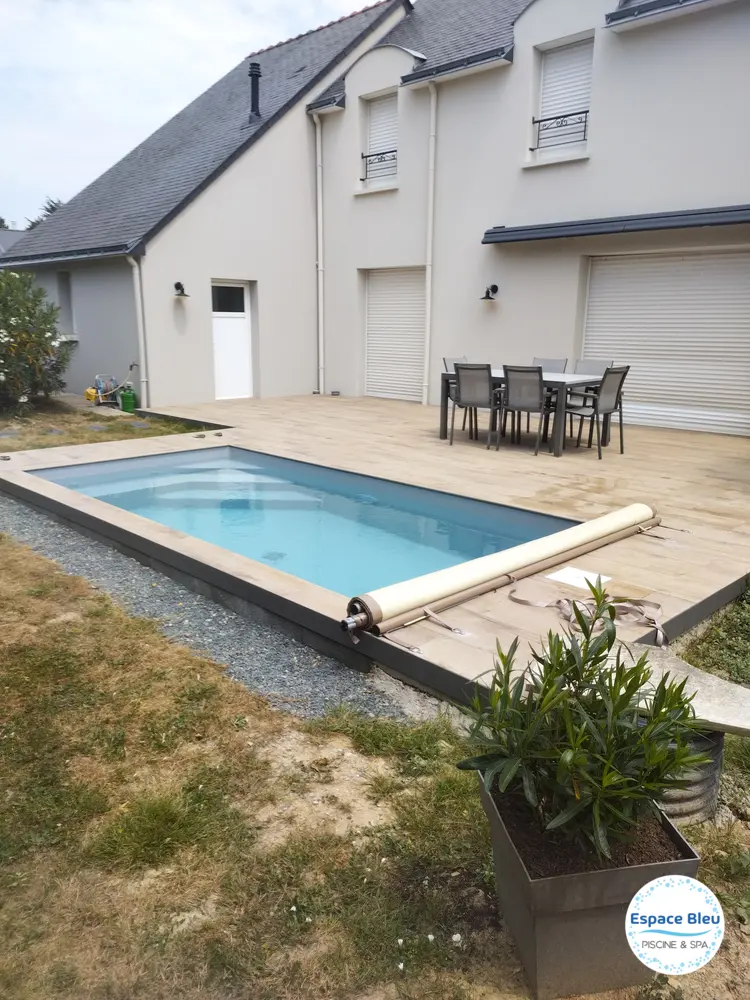 Petite piscine rectangulaire devant une maison