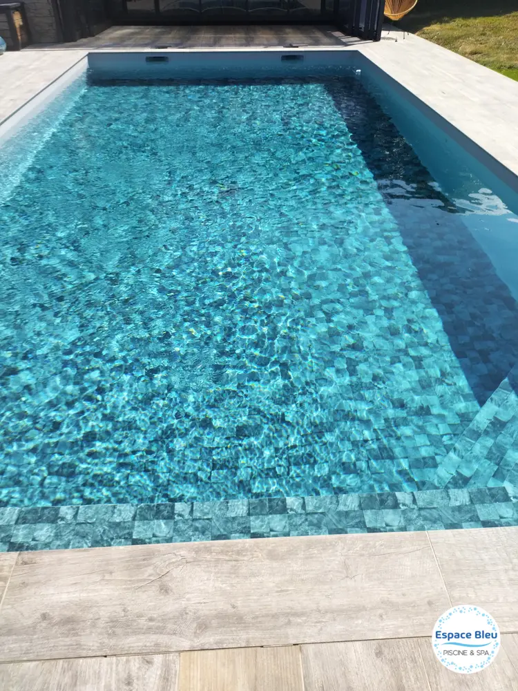 Piscine à eau bleue et revêtement mosaïque