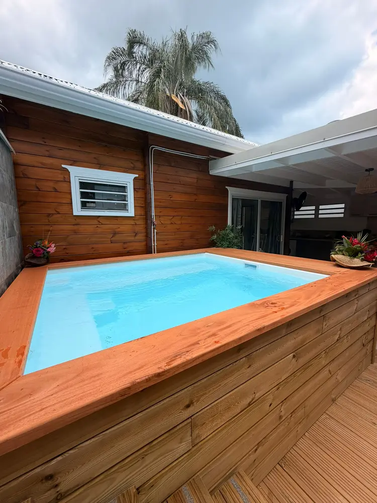 Pool Party encastrée dans une terrasse bois, à côté d’une maison