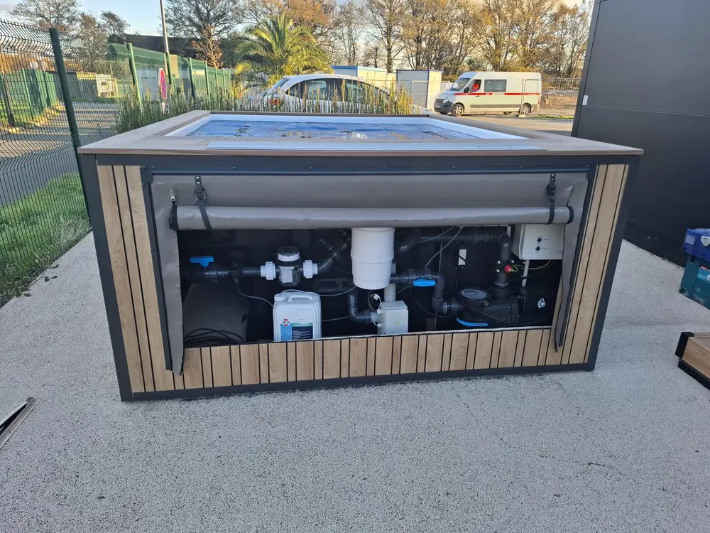 Local technique intégré de la piscine, pompe et filtration regroupées sous le bassin